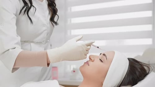In a Medical Clinic a Professional Cosmetologist is Performing a Cosmetic Injection on a Patient The