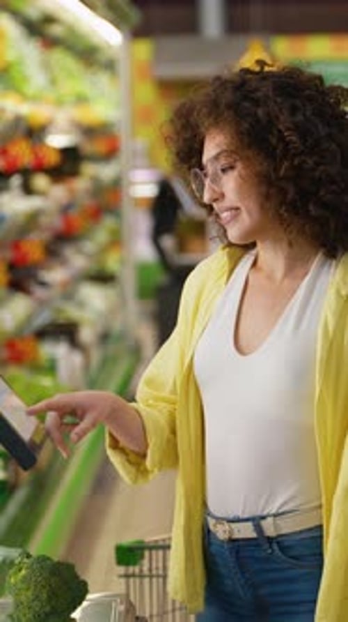 Woman Uses Tablet Device in Grocery Store