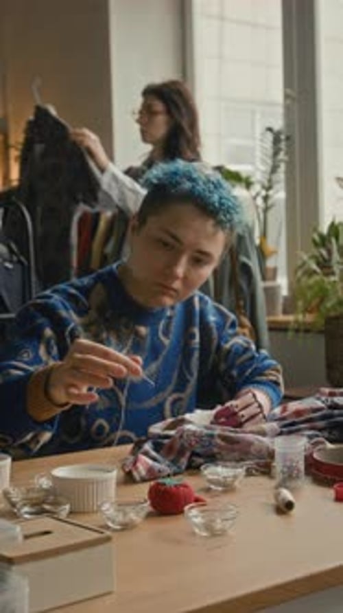 Femme avec prothèse de bras réparant des vêtements dans une friperie moderne
