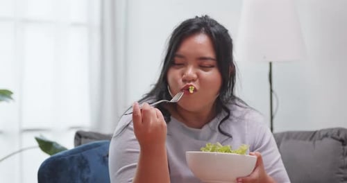 Woman Enjoying a Fresh Green Salad at Home