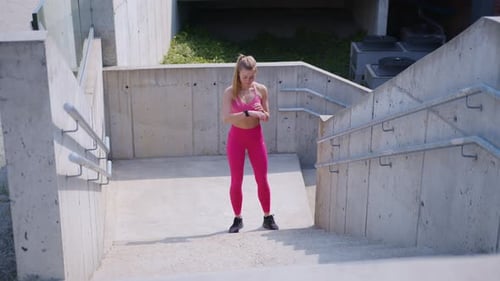 Sporty Woman Jogging Down Concrete Urban Stairway