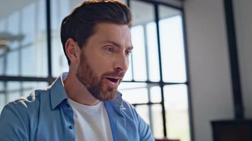 Man with Laptop Cheering in Excitement Indoors