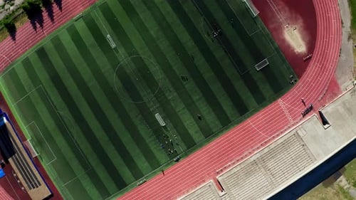 Aerial Shot of a Sports Stadium with a Football Field and a Running Track on the Sides Summer Sports