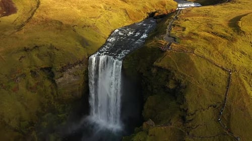 Skogafoss Waterfall Flowing Through Green Cliffs in Iceland