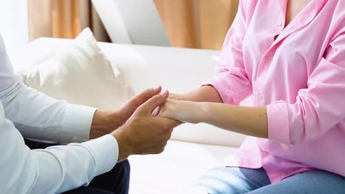 Nahaufnahme eines männlichen Psychologen, der der Frau die Hand auf die Hand legt und gleichzeitig den Patienten tröstet