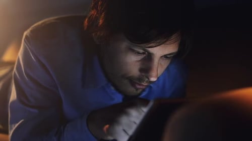 4k video footage of a young businessman using his digital tablet at night at home