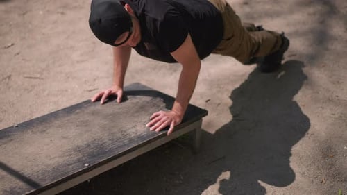 Man Doing Pushups on Bench Press at Outdoor Gym