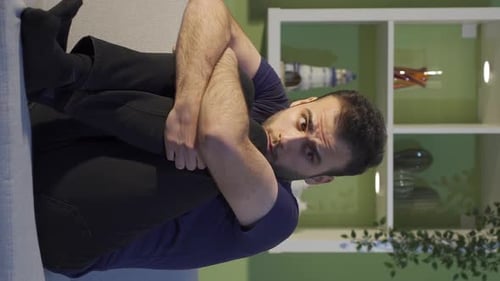 Young Adult Sitting Hugging Knees Indoors