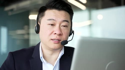 Man in Suit Talking with Headset in Office