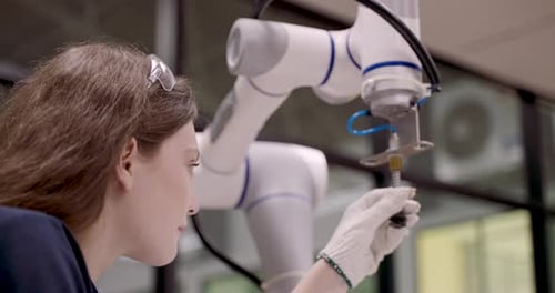 Woman Works With Robotic Arm in Lab