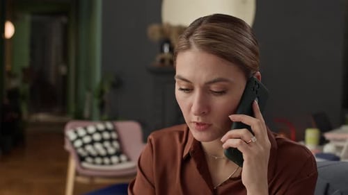 Female Teleworker Talking on Smartphone at Home Office