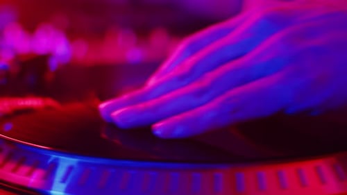 DJ Hands Scratching Record under Blue and Pink Lights