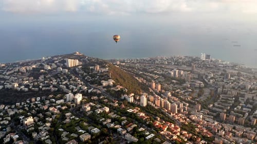 Hot air balloon above Haifa bay and Downtown area at sunrise, Aerial view