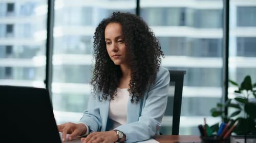 Portrait Of Latin Businesswoman Typing On Laptop Sitting Office Modern Skyscraper. Confident Woma...