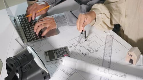 Architect team work for architectural construction with laptop computer they editing on blueprint