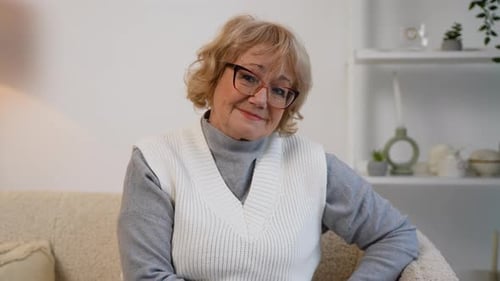 Senior Woman Smiling Comfortably on Couch Indoors