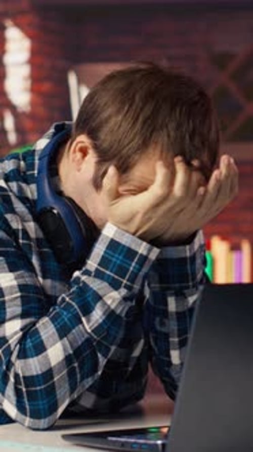Stressed Man Typing at a Laptop Inside