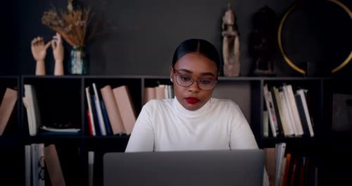 Vergrößern Sie das Porträt einer schönen jungen, intelligenten afrikanischen freiberuflichen Geschäftsfrau, die Laptop zur Arbeit benutzt