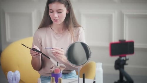 Chica ofrece un tutorial sobre cómo aplicar maquillaje de sombras de ojos en un vlog de belleza