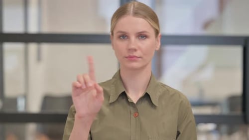 Young Woman Shakes Head and Raises Finger