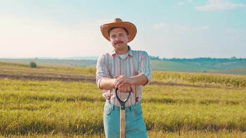 Portrait Shot of the Caucasian Good Looking Male Agricultural Worker in a Hat Standing in the Field