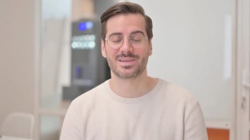 Man Wearing Glasses Smiling and Talking to Camera