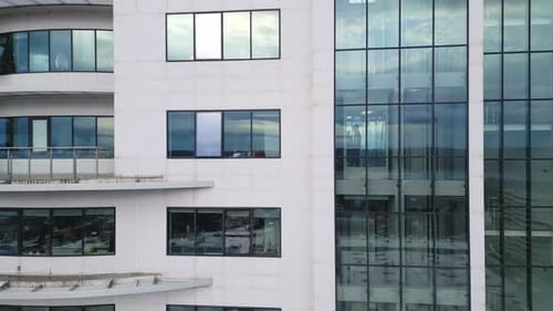 Bürogebäude im Geschäftsviertel mit Wandspiegel mit bewölktem Himmel