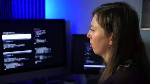 Female programmer programming artificial intelligence language models using code on multiple screens