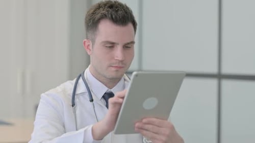 Doctor Using Tablet Device in Hospital Office