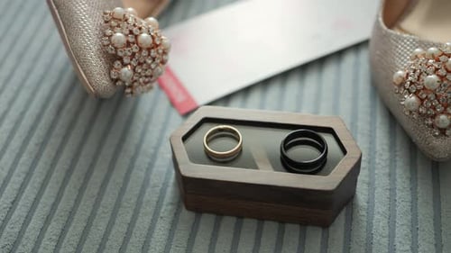 Two yellow and black gold jewelry rings. A pair of wedding rings on a small wooden box and bridal sh