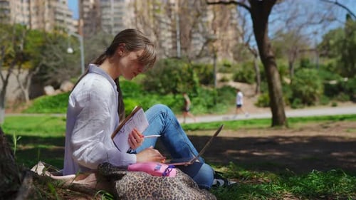 Woman Studies in the Park on Laptop