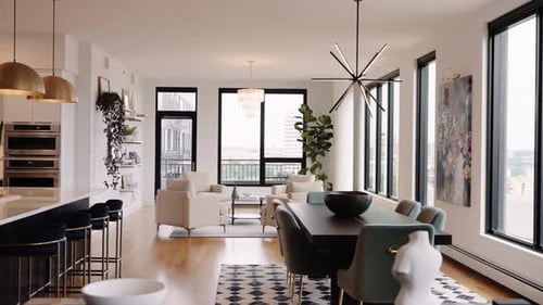 deep parallax shot of a high rise condo showcasing a dining table in the foreground and a seating ar