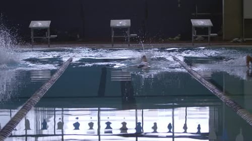 Female swimmers practice freestyle stroke at swimming pool swim meet