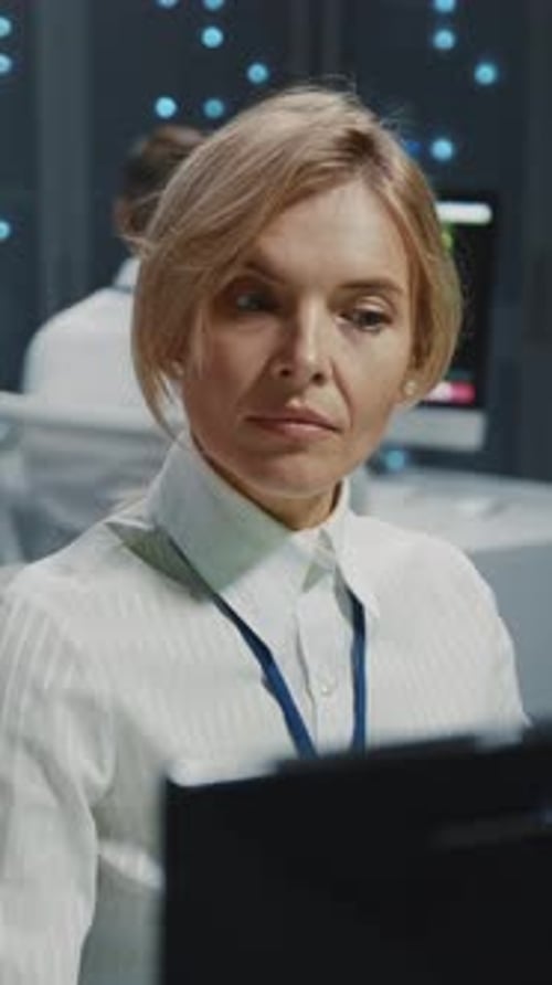 Woman in Server Room Working at Computer Terminal