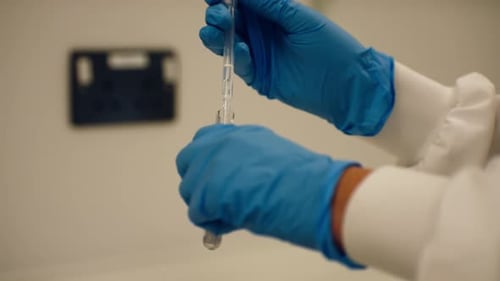 Scientist uses pipette to transfer liquid to test tube