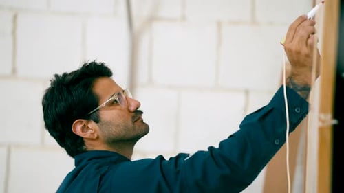 Focused Carpenter Drawing a Straight Line on Wood