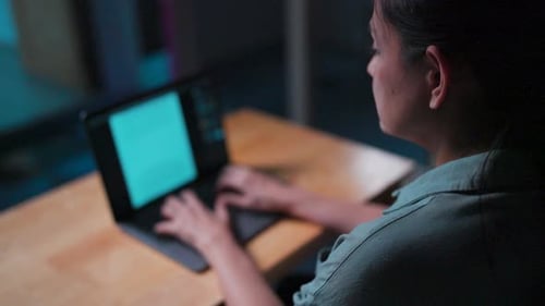 Woman Working on Laptop at Night
