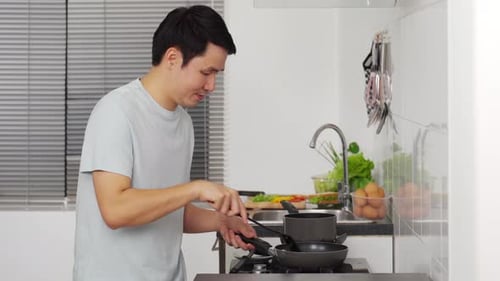 Man Cooking Food in Bright Kitchen