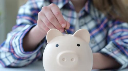 Close Up Kid Girl Saving Money in Piggy Bank Hand Putting Coins in Money Box