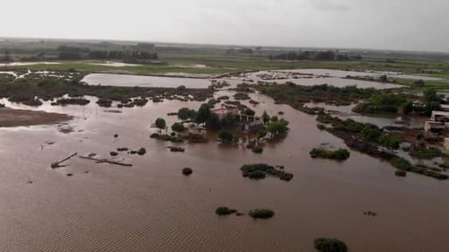 Aerial drone forward moving shot over submerged village house caused due to severe river flooding in