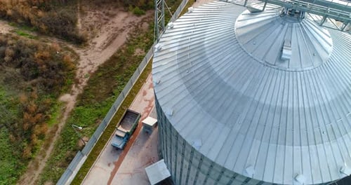 Large storage tank. Modern metal grain elevator on field.