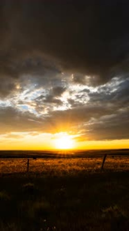Dramatic Golden Sunset over Prairie Landscape with Clouds