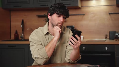 Man Using Smartphone in Modern Kitchen