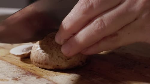Slicing a Mushroom on Cutting Board with Knife
