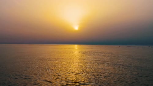 Beautiful calm sea waves moving on ocean over colorful clouds sunset sky background, Bahrain.