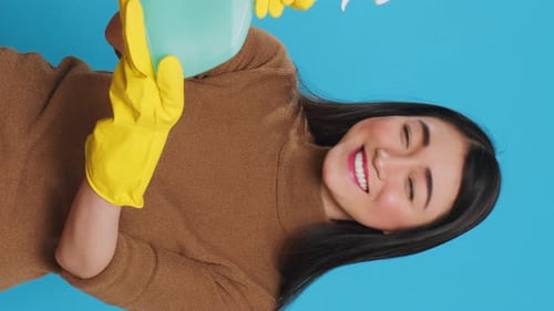 Vertical Video Smiling Asian Maid Wearing Protective Gloves While Showing Chemical Detergent Spray
