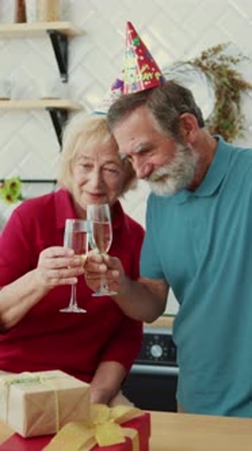 Senior Couple Celebrating at Home With Champagne