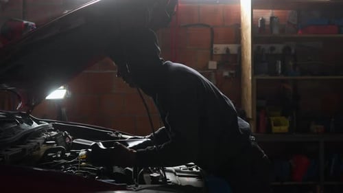Man Working on Car Engine in Garage
