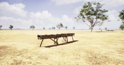 Desolate Landscape with Wooden Bench Under a Wide Blue Sky at Midday