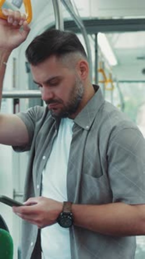 Man Using Smartphone on Modern Public Bus